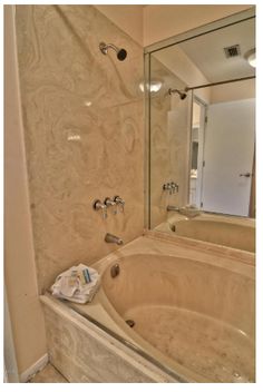 a bath tub sitting under a bathroom mirror