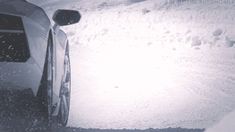 a car parked in the snow next to a hill covered with snow and ice flakes