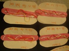 four hotdogs with writing on them are displayed