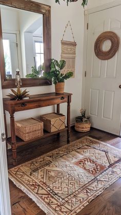 a room with a rug, mirror and potted plants