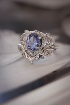 a ring with an oval shaped tanzante stone surrounded by filigrees