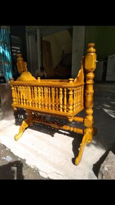 a wooden bed frame sitting on top of a sidewalk