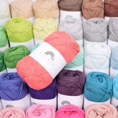 many balls of yarn are arranged in different colors and sizes, including multi - colored