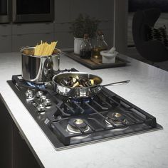 a stove top with some pots and pans sitting on it's burners