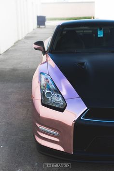 the front end of a pink and black sports car