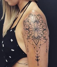 a woman's arm with a tattoo on it that has a flower and diamond design