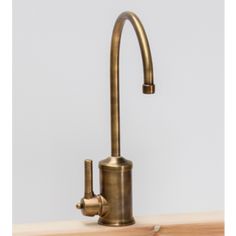 an antique brass faucet on a wooden counter