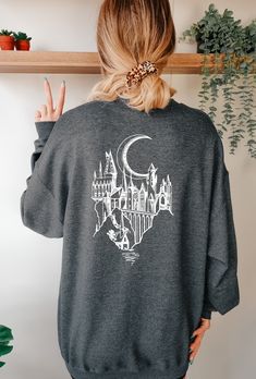 Stay warm and stylish with this Hogwarts Castle themed Sweater. Made from dark grey heather fabric, this soft and cozy garment is perfect for Harry Potter fans who want to represent the wizarding world in their style. Small Shirt Outfit, Harry Potter Tshirt Ideas, Hogwarts Sweater, Outfit Ideas Shirt, Harry Potter Sweater, Universal Studios Outfit, Shirt Outfit Ideas, Shirt Design Ideas, Harry Potter Sweatshirt