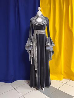 The dress is made from artificial velvet in gray color. Sleeves and a belt are decorated with the wide silver knitted and woven braid. The main decoration of a dress is sleeves which beautifully fall down and have the real elfin appearance. There aren't any fasteners on the dress, thanks to ability of fabric it is good to stretch. The suit consists of a dress and a belt. Material: velvet. The dress can be made in any size. Production of a dress takes 7-10 working days. Winter Medieval Dress, Medieval Fantasy Dress Princesses, Velvet Medieval Dress, Queen Dress Royal Medieval, Dnd Dress, Northern Fashion, Daenys Targaryen, Silver Wedding Gowns, Owl Wizard