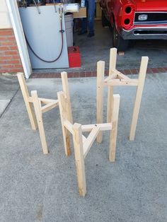 three pieces of wood sitting in front of a red car