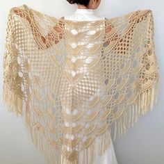 a woman is wearing a crocheted shawl