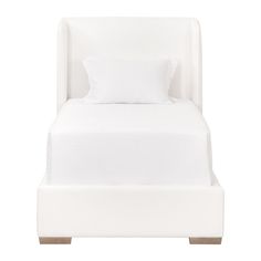 a white bed with two pillows on top of it and a night stand underneath the bed