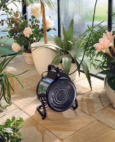 an air vent sitting on top of a stone floor next to potted plants