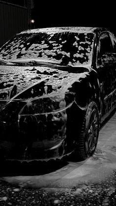 black and white photograph of a car covered in ice