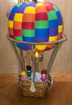 a hot air balloon with two people inside it on a wooden floor next to a wall