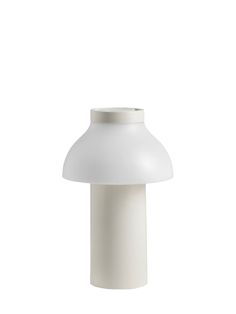 a white table lamp on a white background with the light turned off to show its dim lighting