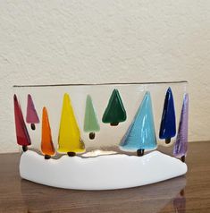 a group of colorful glass cones sitting on top of a wooden table next to a white wall