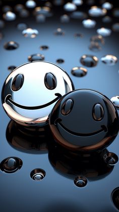 two black and white smiley faces sitting on top of some water droplets in the air