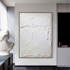 a large white painting hanging on the side of a wall