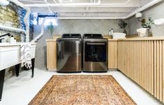 a kitchen with an area rug on the floor and two appliances in front of it