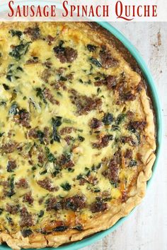 sausage spinach quiche in a blue dish on a white table with text overlay