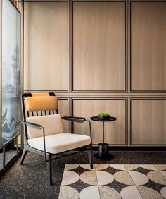 a chair sitting next to a table on top of a checkered floor