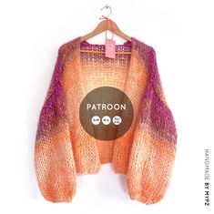 an orange and purple knit sweater hanging on a hanger with the label knit pattern