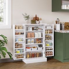 a kitchen with green cabinets and white shelves filled with spices, condiments and other items