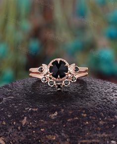 a black diamond ring sitting on top of a rock