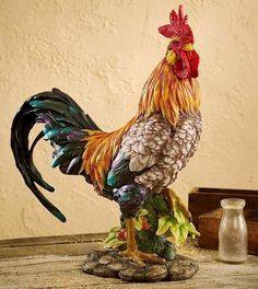 a rooster statue sitting on top of a wooden table