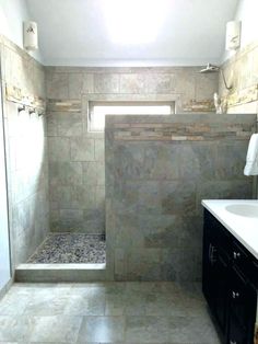 a bathroom with a walk in shower next to a white sink and toilet under a window