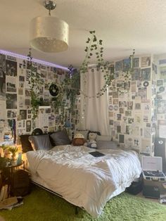 a bed sitting in a bedroom next to a window covered in pictures and plants on the wall