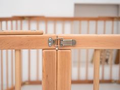 a wooden crib with a metal latch on the top and bottom bars that are closed