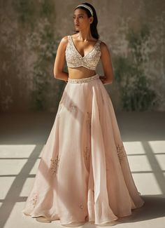 This exquisite Champagne Pink Embroidered Lehenga Set showcases a timeless blend of elegance and craftsmanship. Crafted from luxurious pure satin silk organza, the flowing champagne pink lehenga features stunning hand-embroidered motifs that add a touch of artistic allure to the piece. Paired with a matching blouse, it boasts intricate embroidery that highlights the detailed craftsmanship and elegance of the design. Completed with a dupatta adorned with a hand-embroidered border and delicate ruffles at both ends, this ensemble adds a graceful finish to any occasion. Perfect for a bride or bride-to-be on your special day, this outfit promises to make you feel both confident and enchanting, with its seamless blend of traditional artistry and contemporary style. Composition : Lehenga - Pure S Elegant Organza Lehenga With Pearl Embroidery, Glamorous Organza Lehenga With Pearl Embroidery, Silk Lehenga With Pearl Embroidery For Reception, Glamorous Embroidered Organza Lehenga, Elegant Pink Silk Choli, Elegant Organza Lehenga With Intricate Embroidery, Glamorous Silk Lehenga With Zari Work, Elegant Embroidered Organza Lehenga, Elegant Pink Tissue Silk Lehenga