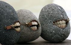 two rocks with teeth on them and one is biting the other's teeth out