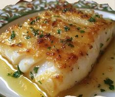 a close up of a fish on a plate with sauce and parmesan cheese