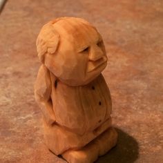 a wooden statue of a person sitting on the ground