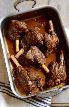 a pan filled with meat and sauce on top of a table