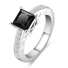 a white gold ring with black and white diamonds on the sides, set in 18k white gold