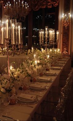 a long table is set with candles and flowers for an elegant dinner or party event