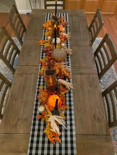 the table is set with candles and fall leaves on it, along with other decorations