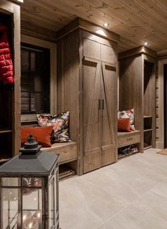 a room that has some wooden doors and pillows on it's shelves in front of the closet