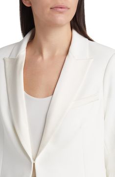 Satin lapels add a formal touch to a snowy blazer fastened with a single hook-and-eye for a clean-lined silhouette. 30" length Front hook-and-eye closure Peaked lapels Three-button cuffs Chest welt pocket; front welt pockets Lined 100% polyester Dry clean Imported Elegant Wedding Blazer With Concealed Placket, Elegant Single Button Tuxedo For Workwear, White Structured Outerwear For Formal Occasions, Timeless Single Button Wedding Blazer, Sleek White Outerwear For Office, Chic Notch Lapel Tuxedo With Pressed Crease, White Blazer With Concealed Placket And Lapel Collar, Chic Tuxedo With Notch Lapel And Pressed Crease, Elegant Structured Blazer With Concealed Placket