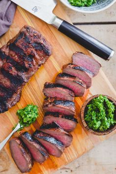 sliced up steak on a cutting board with garnishes