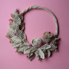 a crocheted wreath with two little birds on it and leaves around the edges