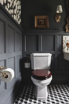 a white toilet sitting in a bathroom next to a black wall