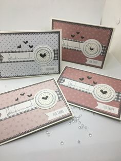 three cards with hearts and ribbons on them, one has a clock in the middle