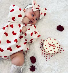 a baby is laying on the floor next to a cake