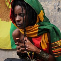 a woman with dreadlocks sitting on the ground