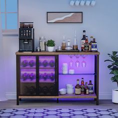 a bar with purple lighting and liquor bottles on the top shelf next to a potted plant